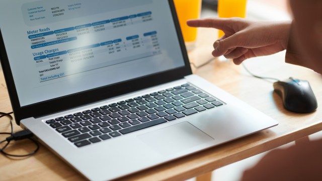 A person points at a laptop screen.