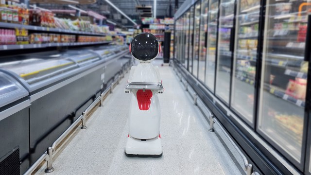 A robot in a grocery store aisle.
