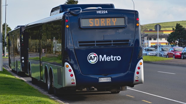 An Auckland, New Zealand, metro bus with a sign displaying "SORRY" parked on the side of the road.