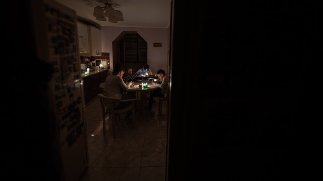 A family around a kitchen table during a blackout.