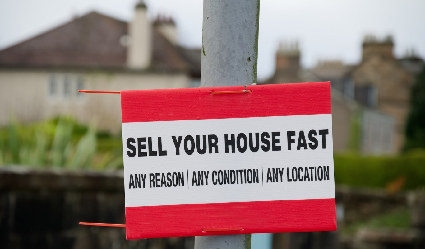 A sign that reads "SELL YOUR HOUSE FAST" with additional offers below.