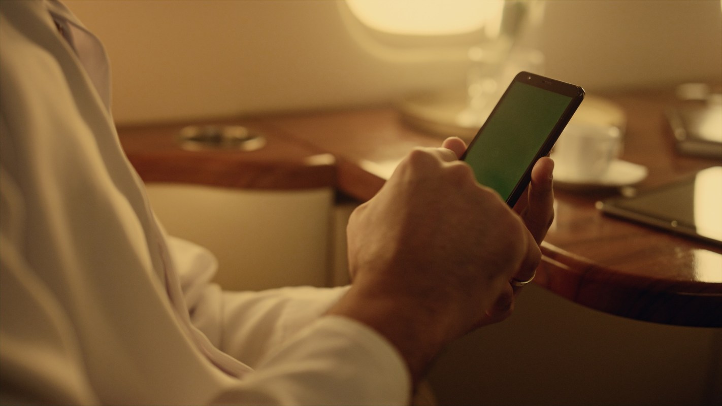 A person uses a smartphone on a private jet.