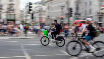 A person on an e-bike cycling through an intersection.