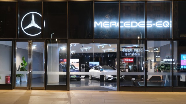 A Mercedes-Benz EQ dealership showcasing electric cars behind large glass windows with Chinese characters.