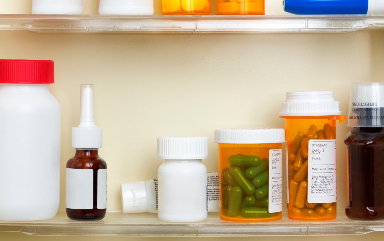 Various prescription bottles and containers lined up on a shelf.