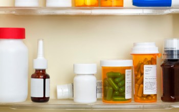 Various prescription bottles and containers lined up on a shelf.