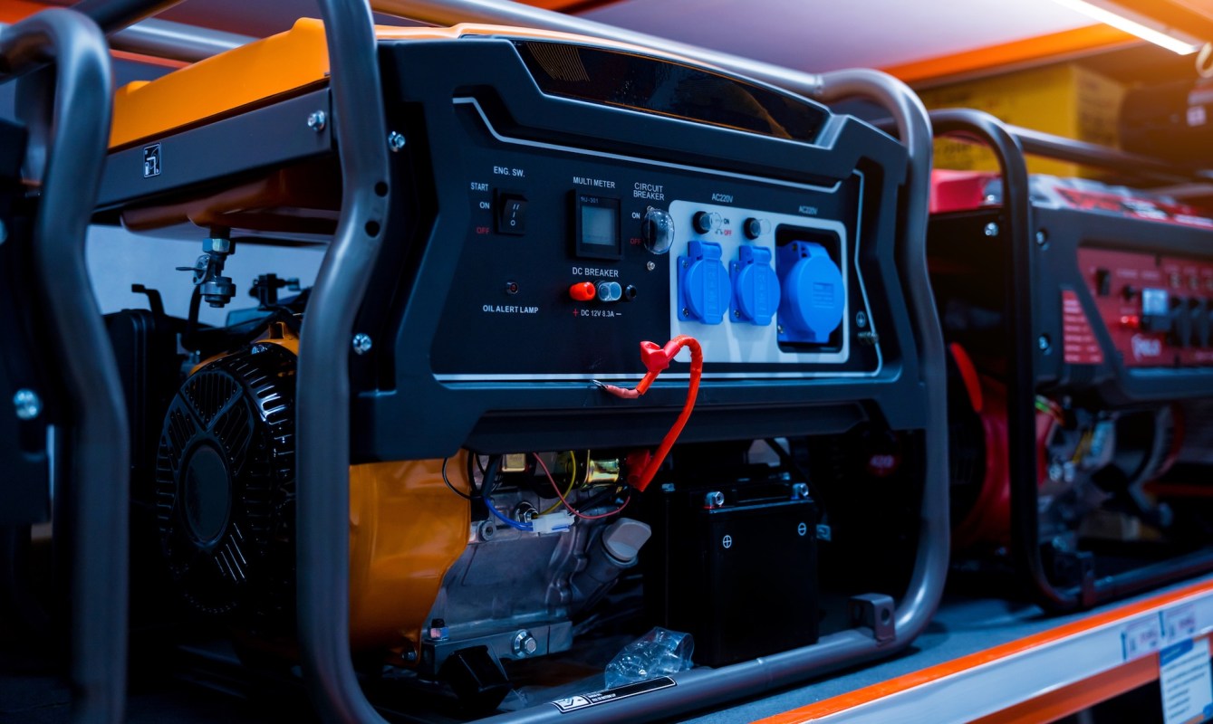 A close-up of a portable generator with various switches, meters, and power outlets.