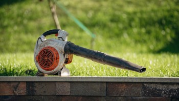 A leaf blower on a stone wall.