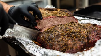 A person slicing brisket.
