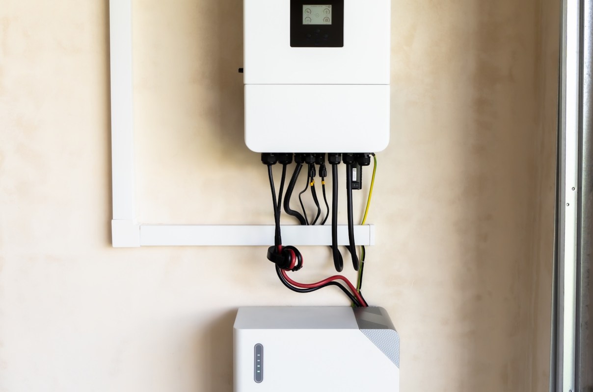 A wall-mounted energy storage system with connected cables.
