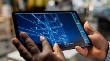 A person interacts with a tablet displaying technical diagrams of power transmission lines.