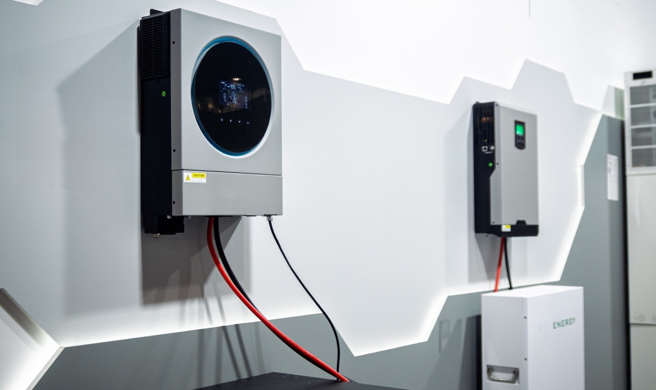 Two energy storage units mounted on a wall with visible wiring.