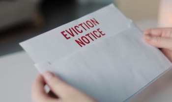A person holds an envelope labeled "EVICTION NOTICE" in red letters.