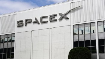 The SpaceX logo displayed on the exterior of a building.