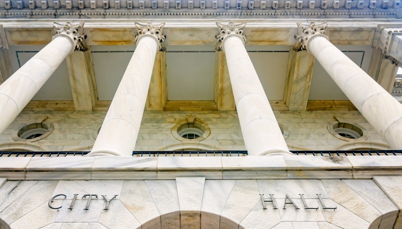 A view of the columns and facade of a City Hall building.