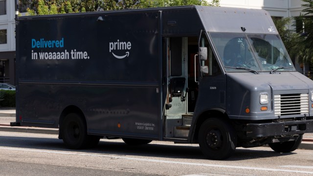 An Amazon delivery truck parked on the side of the road with a promotional message on its side.