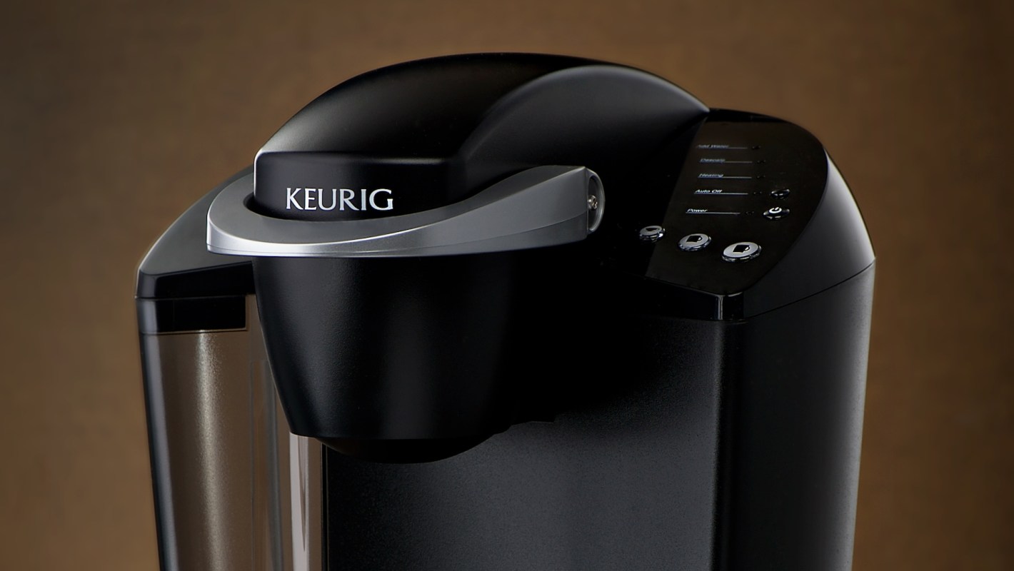 A black Keurig coffee maker with various buttons and a transparent water reservoir.