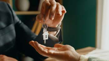 A person placing keys in someone's hand.