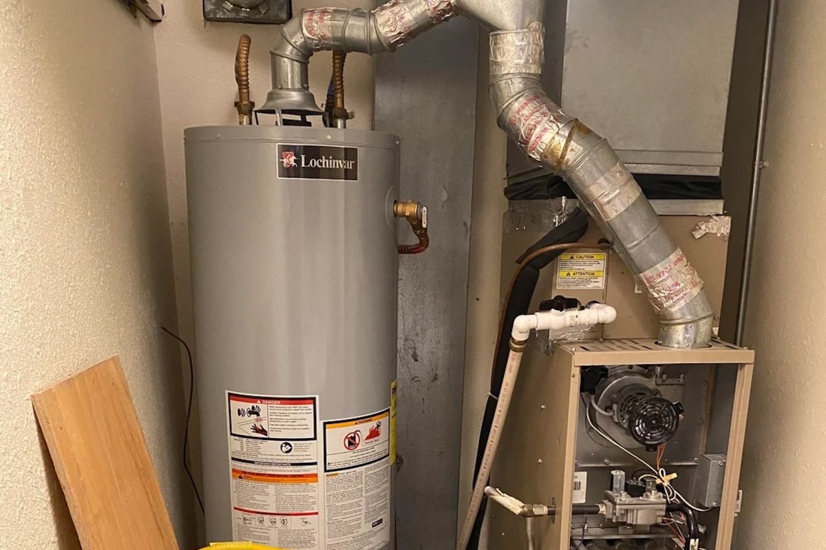 A Lochinvar water heater and furnace with exposed ductwork in a utility space.