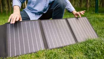 A person setting up a portable solar panel.