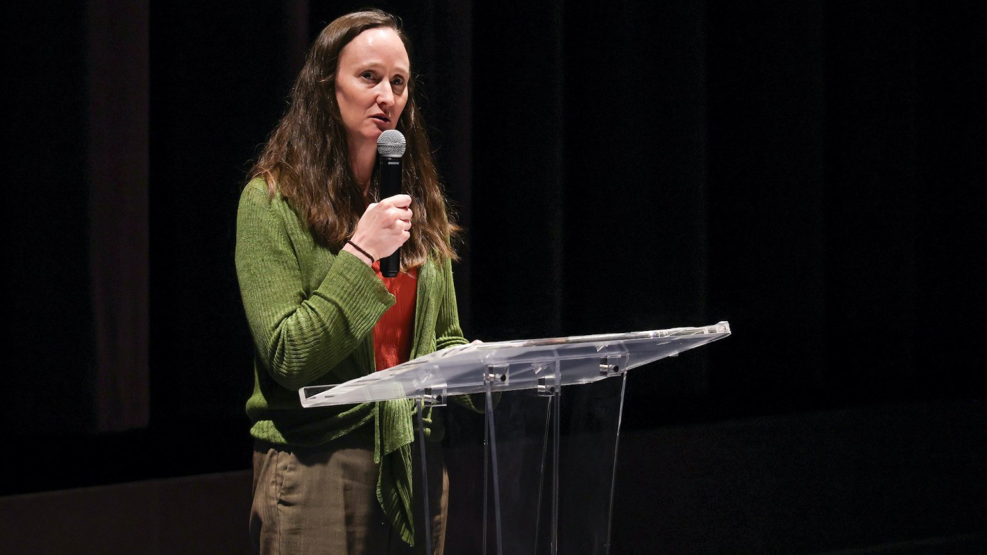 Seattle mayor Katie Wilson speaks at a podium while holding a microphone.