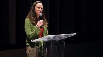 Seattle mayor Katie Wilson speaks at a podium while holding a microphone.