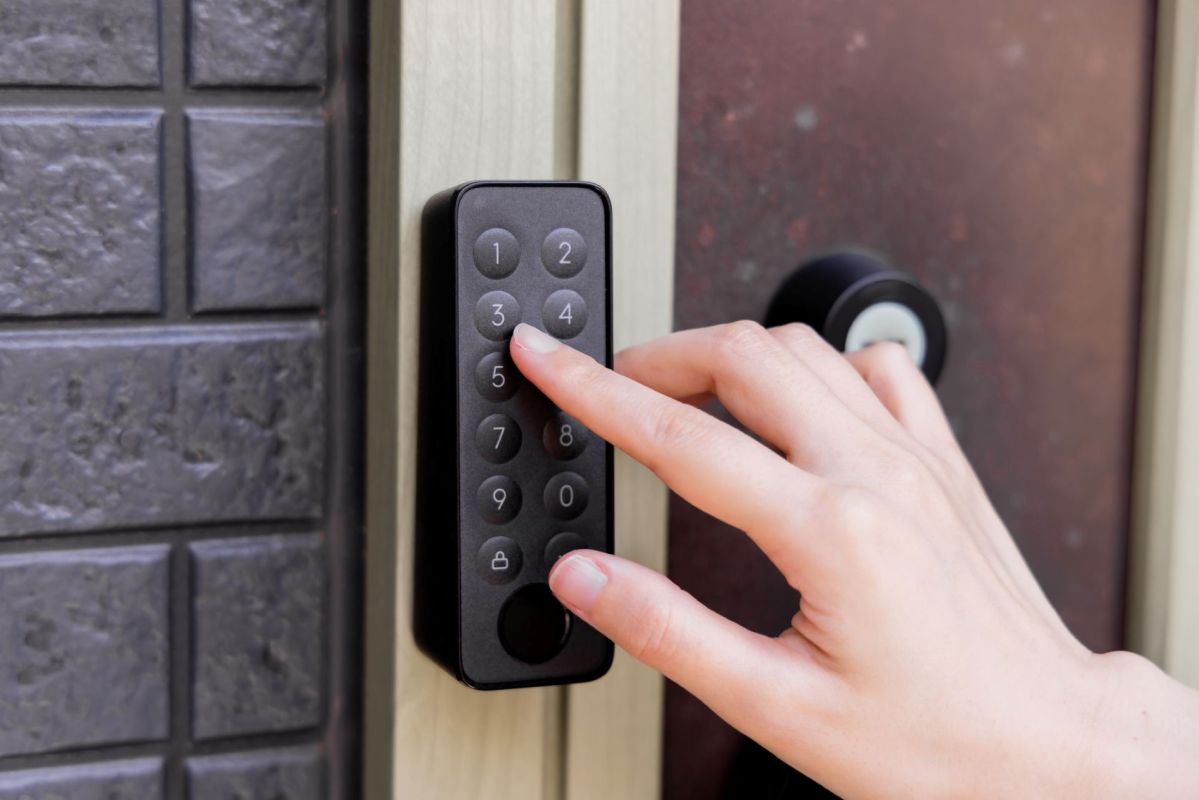 A person pressing numbers on a keypad outside of a home.