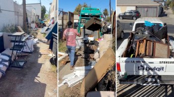 An alley filled with discarded furniture and debris, with a truck collecting items for removal.
