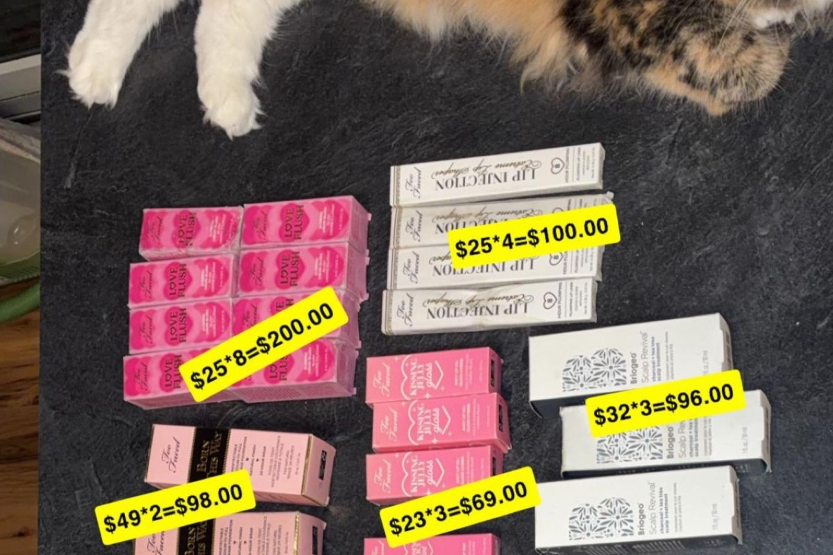 Multiple boxes of cosmetics displayed on a surface with a cat's paws visible at the top.