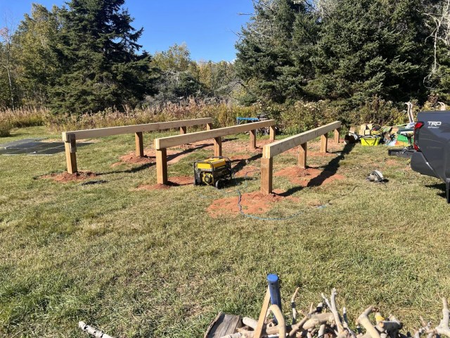 Three wooden beams constructed on grass.