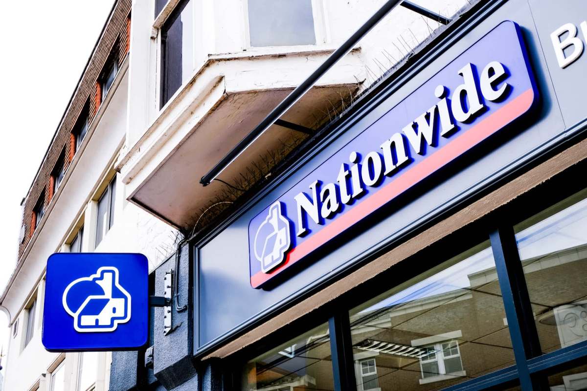 A sign for Nationwide, featuring a house icon and blue background, mounted on a building exterior.