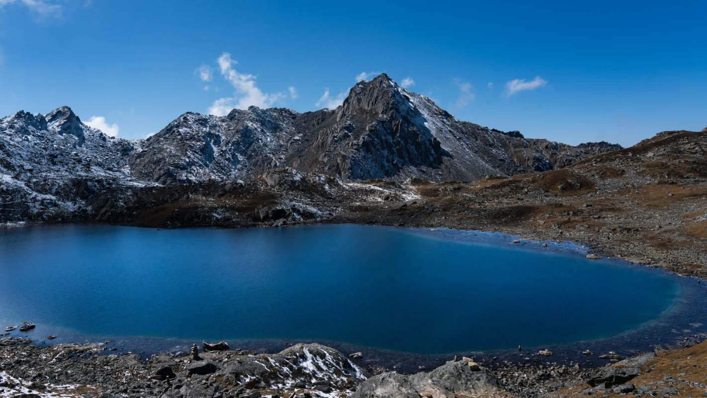 A tranquil blue lake surrounded by rocky mountains and a clear blue sky.