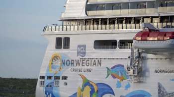 A Norwegian Cruise Line ship with colorful marine-themed artwork on its side.