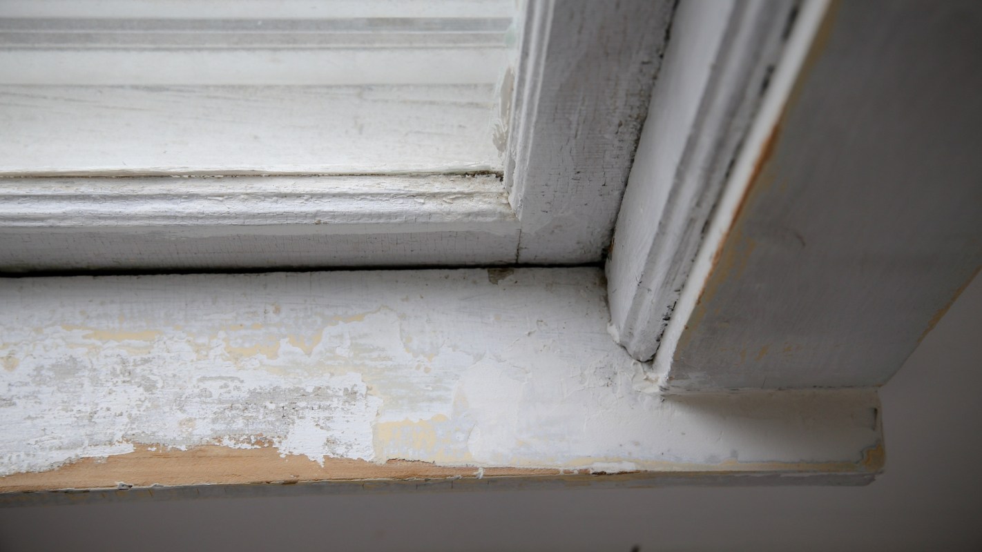 A worn window sill with chipped paint and visible wear.