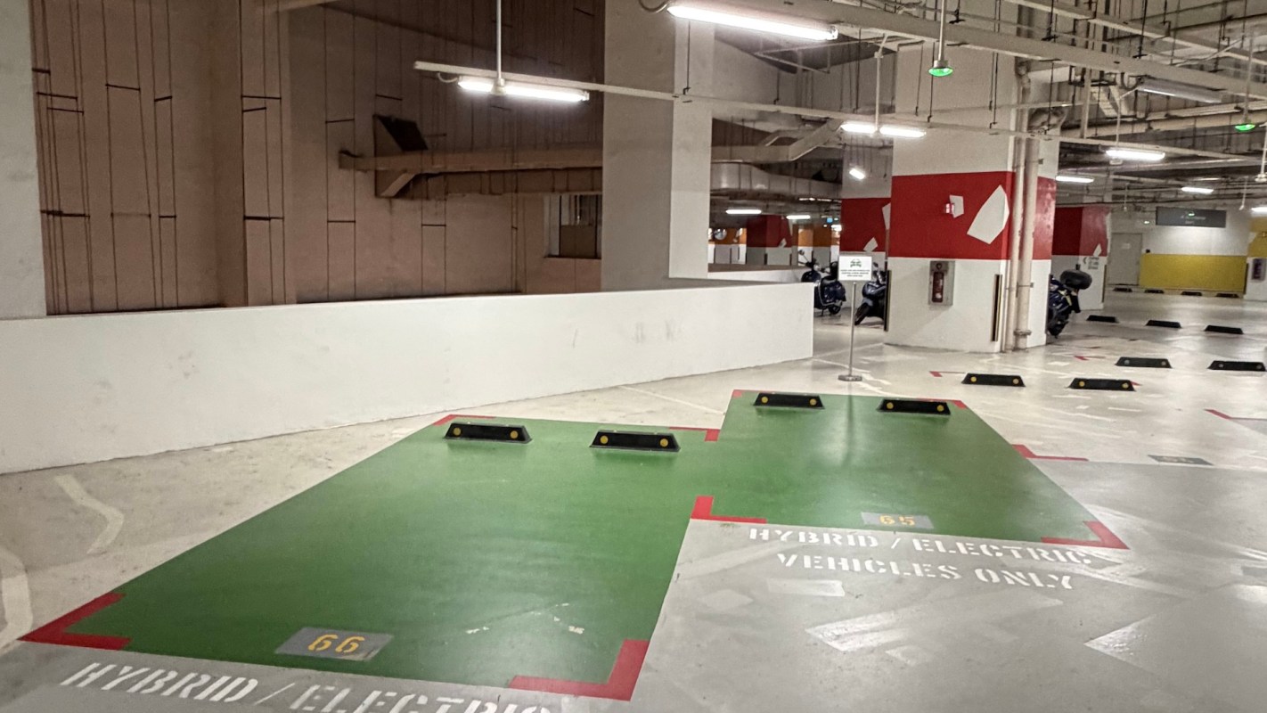 Parking spaces designated for hybrid and electric vehicles, marked with green paint and signage.