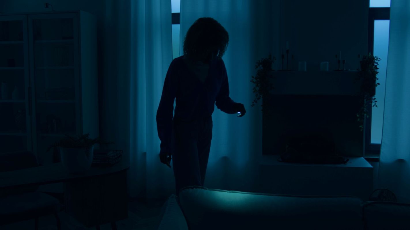 A woman standing inside during a power outage.