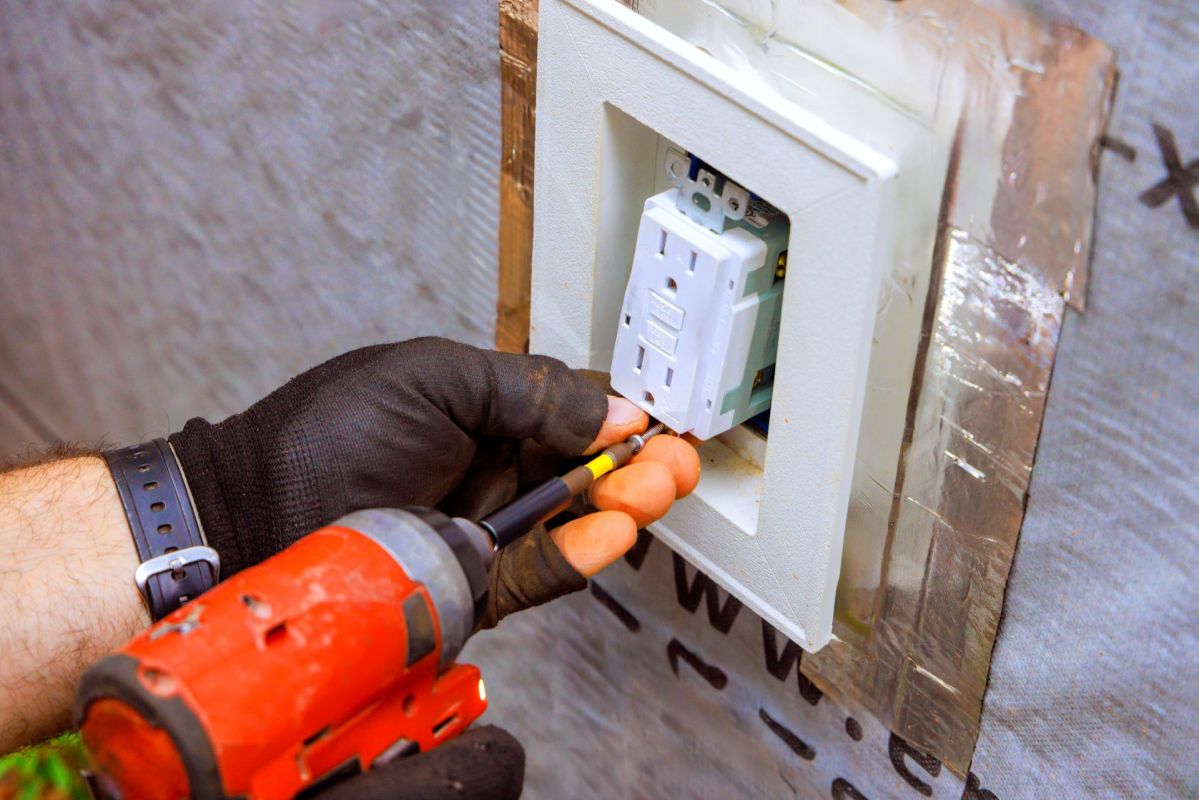 An electrician installing an electrical outlet.
