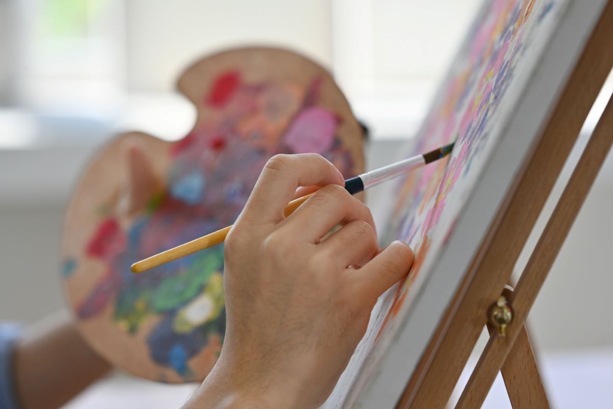 An artist painting on a canvas.