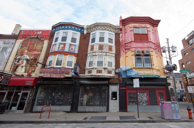 Colorful buildings with artistic murals and storefronts in an urban setting.