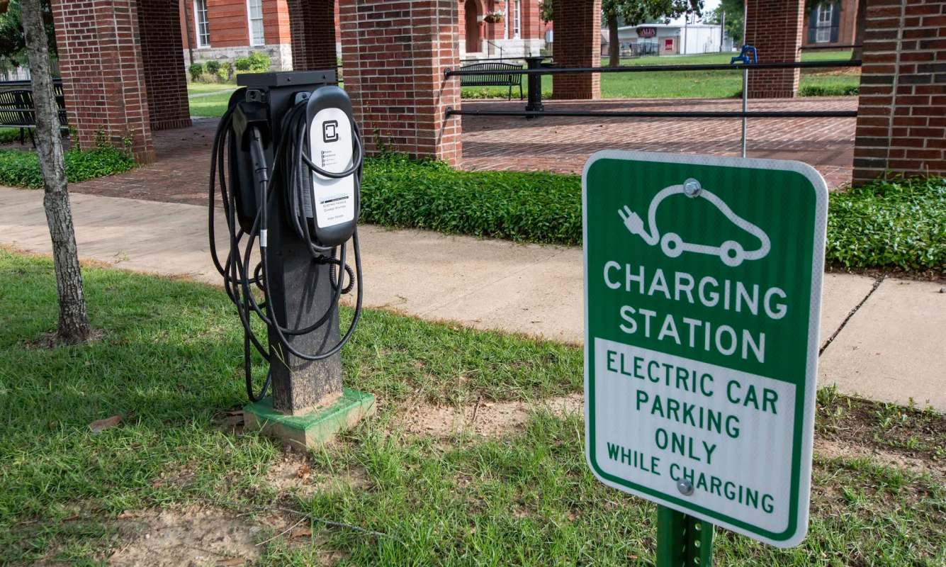 An electric vehicle charging station with a sign indicating designated parking for charging only.