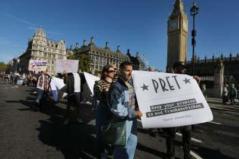 Protesters hold signs advocating against animal abuse near the Big Ben clock tower in London.