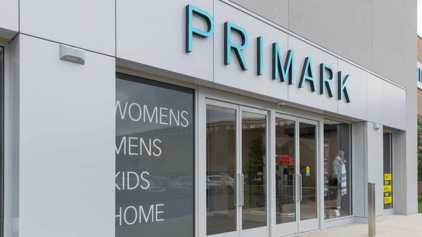 A Primark store exterior featuring signage for women's, men's, kids', and home sections.