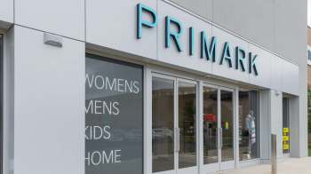 A Primark store exterior featuring signage for women's, men's, kids', and home sections.