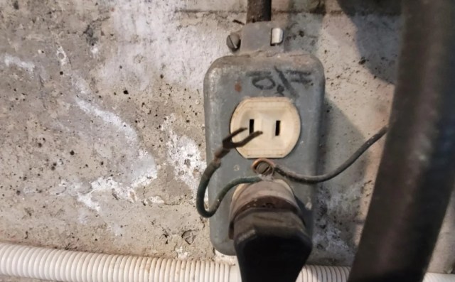 A pronged wire sticking out of an outlet.