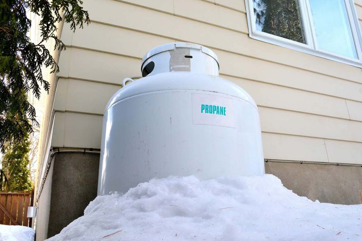 A propane tank partially buried in snow.