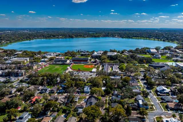 An aerial view of Lakeland Florida with a lake surrounded by residential areas and a baseball field.