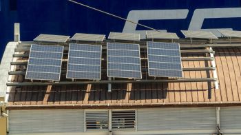 Solar panels are installed on a rooftop in the Dominican Republic with brown tiles.