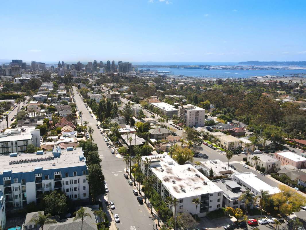 Aerial view of a coastal city with residential areas and a harbor in the background.