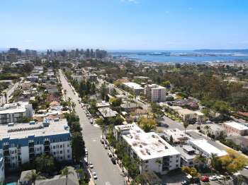 Aerial view of a coastal city with residential areas and a harbor in the background.