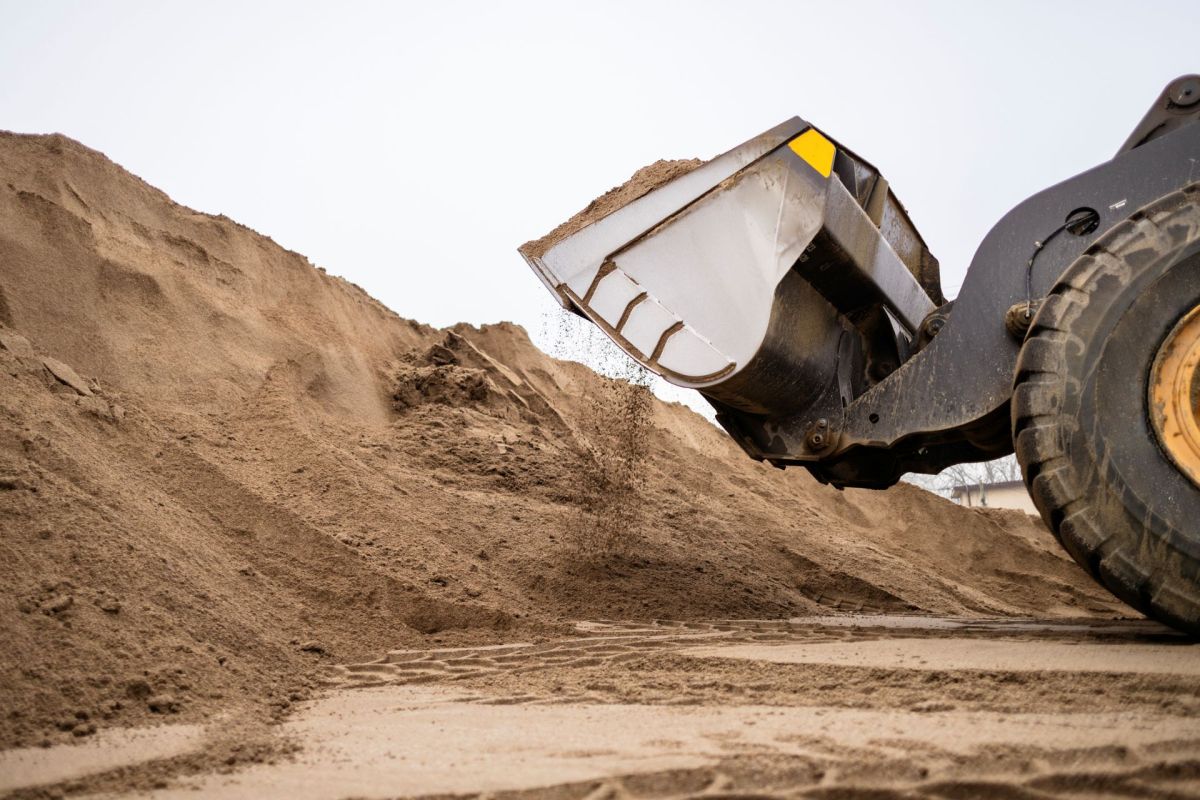 A loader moving sand at a construction site.